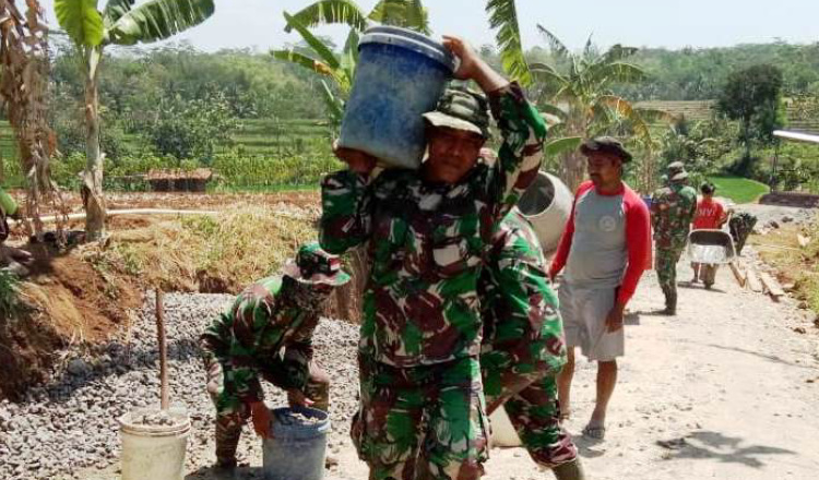 Demi Sukses TMMD,  Anggota TNI Ini Rela Menjadi  Asisten Tukang Batu