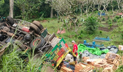Truk Jurusan Jakarta Muat Jeruk dan Cabe Terguling ke Area Pemakaman di Glenmore Banyuwangi