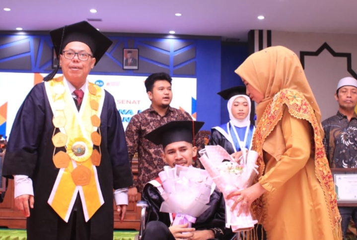 Irul, Wisudawan Pascasarjana UIN KHAS Jember yang Tetap Semangat Menghadiri Prosesi Wisuda Meskipun Menggunakan Kursi Roda